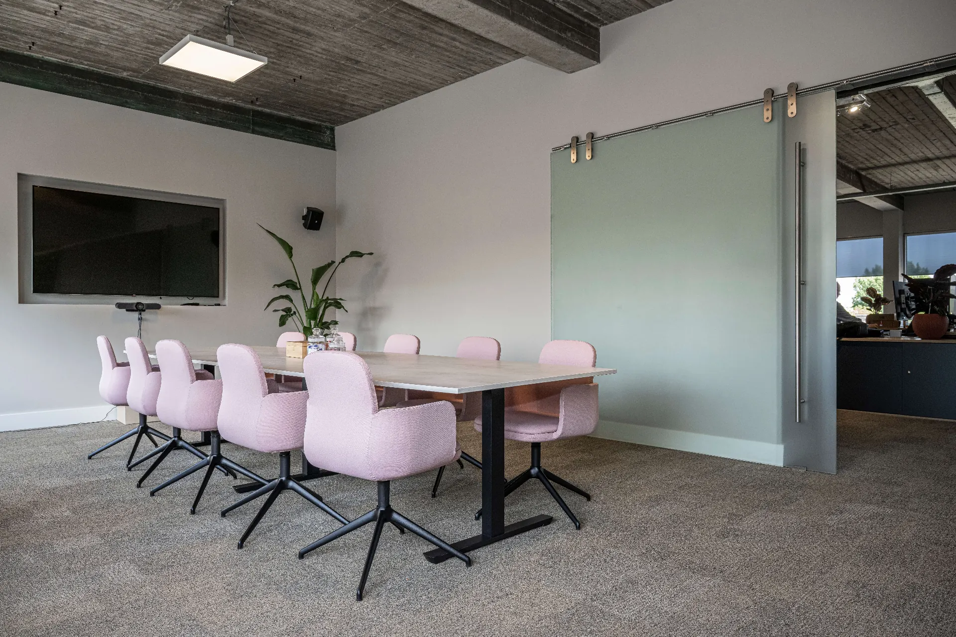 Vergaderruimte met beeldscherm en flexibele glazen wand