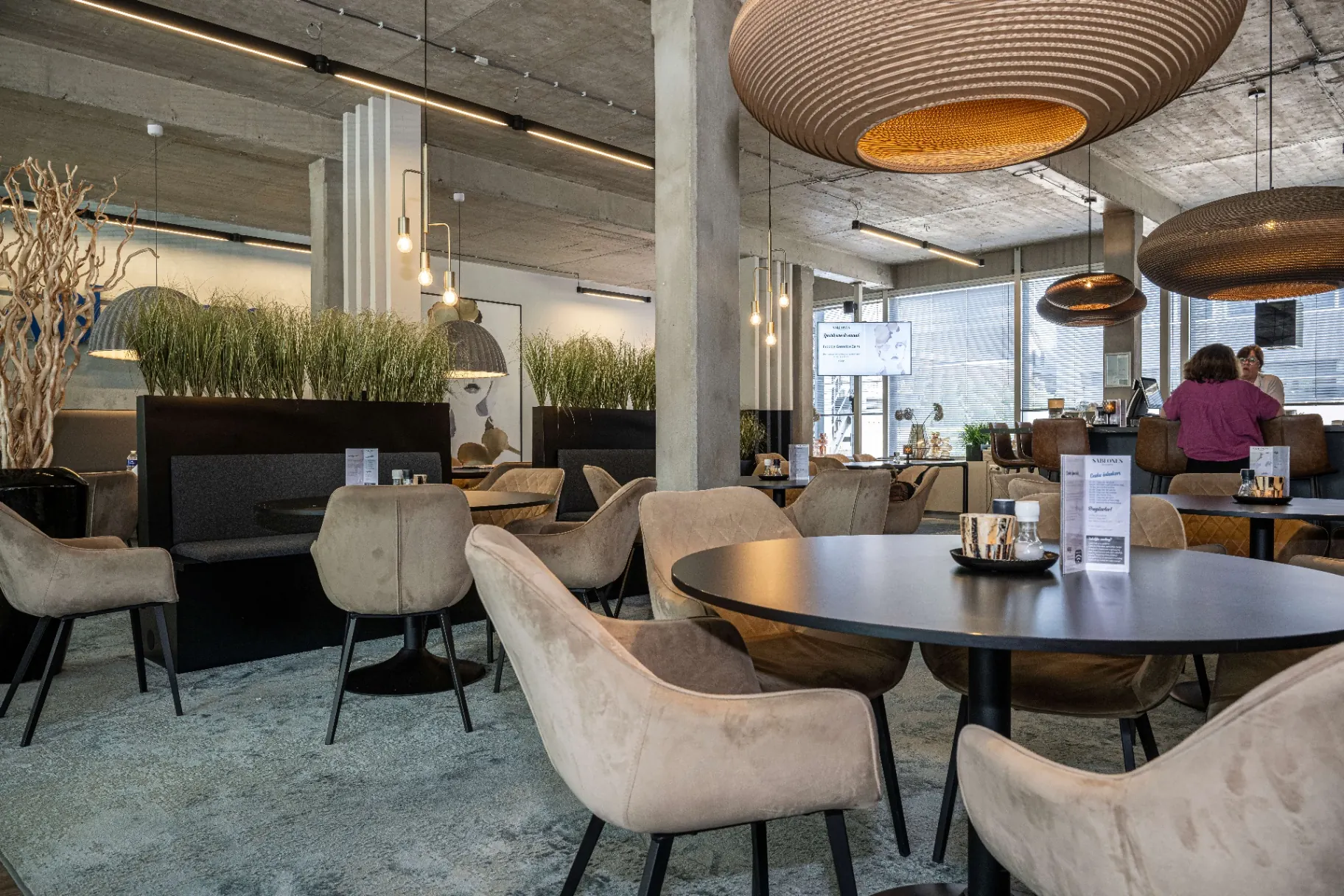 Sfeervolle koffie- en loungeruimte met velvet zitjes en design-verlichting