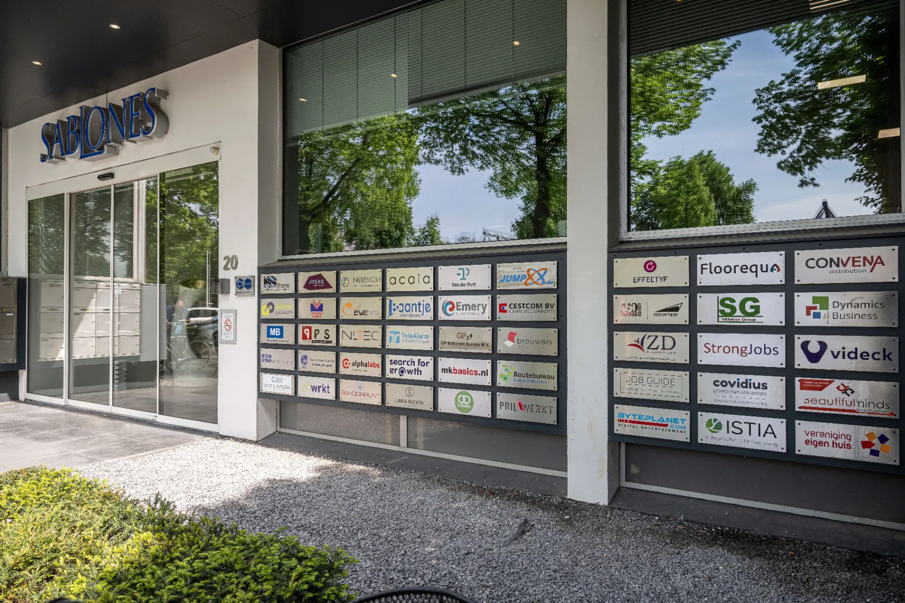 Community wall met logo's van huurders bij Sablones Venlo